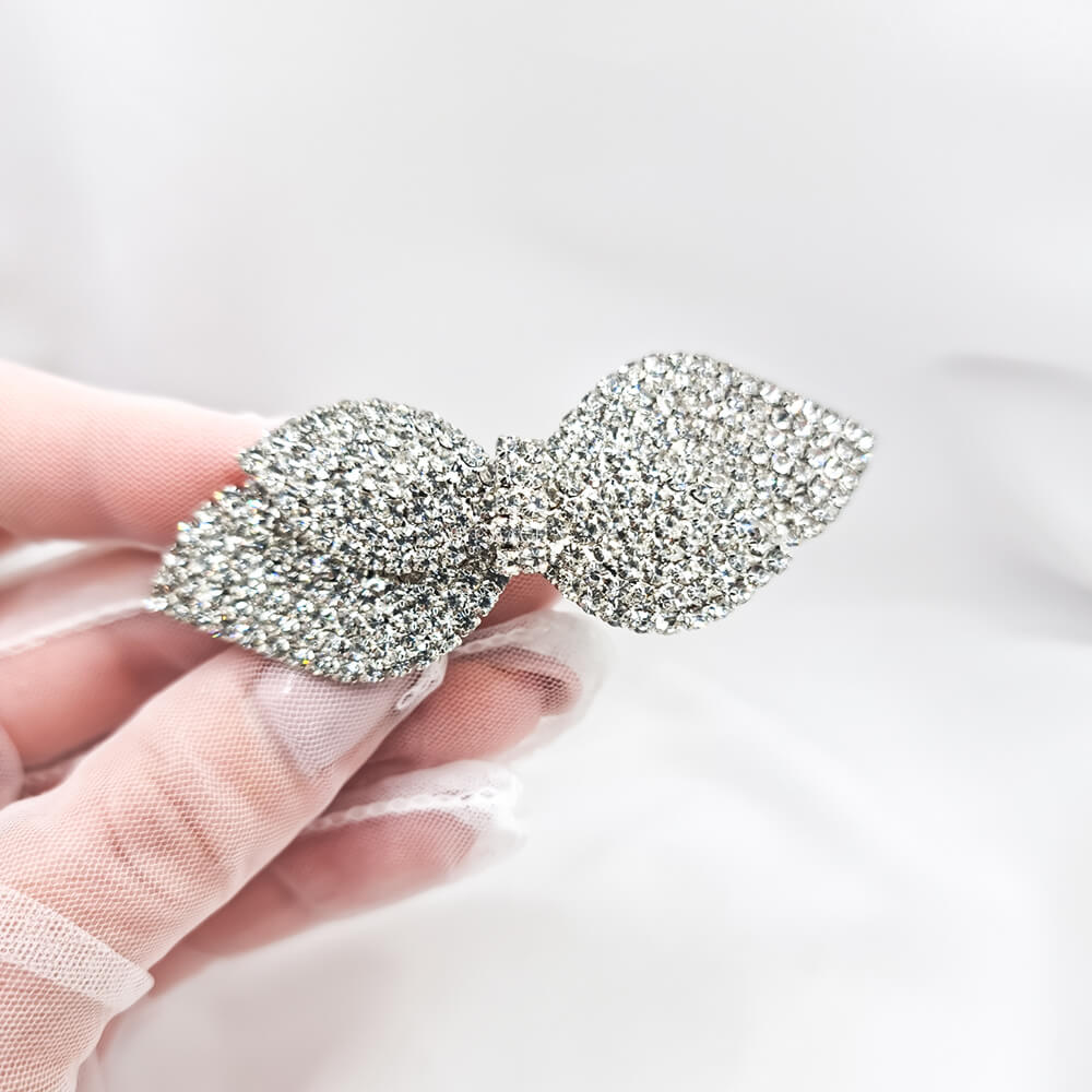 Agrafă de păr metalică, argintie, decorată cu pietricele, model fundiță, mireasă