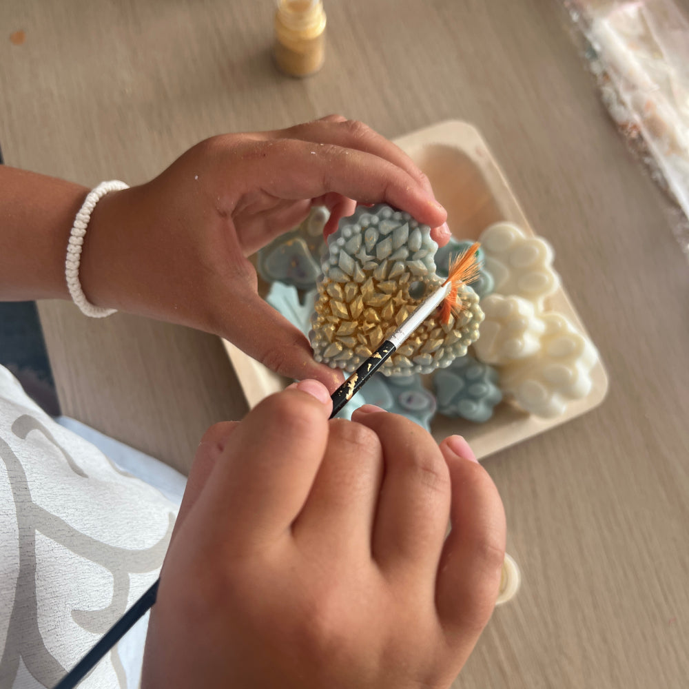 Copii pictând figurine parfumate în cadrul unui atelier creativ