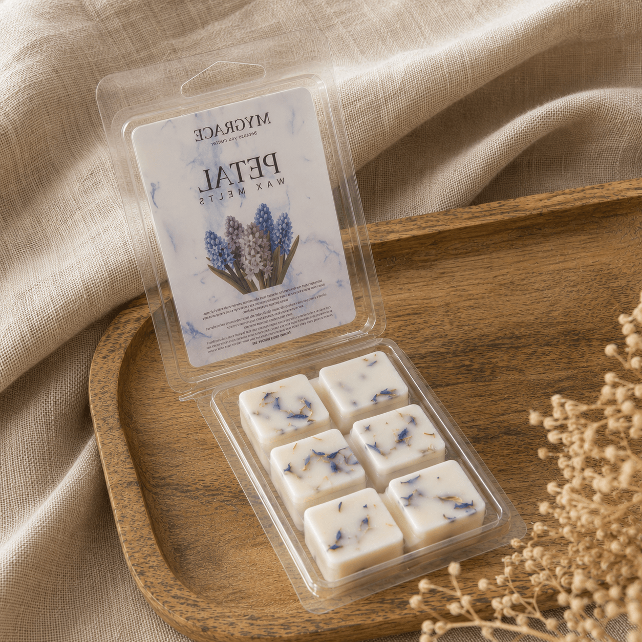 Ceară naturală de soia MYGRACE cu parfum de zambilă într-un clamshell deschis, decorată cu petale albastre și fotografiată într-un decor natural.