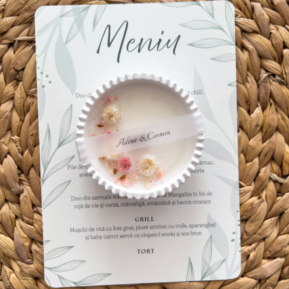 Mărturie de nuntă parfumată în recipient ceramic alături de un meniu de nuntă personalizat cu design floral natural